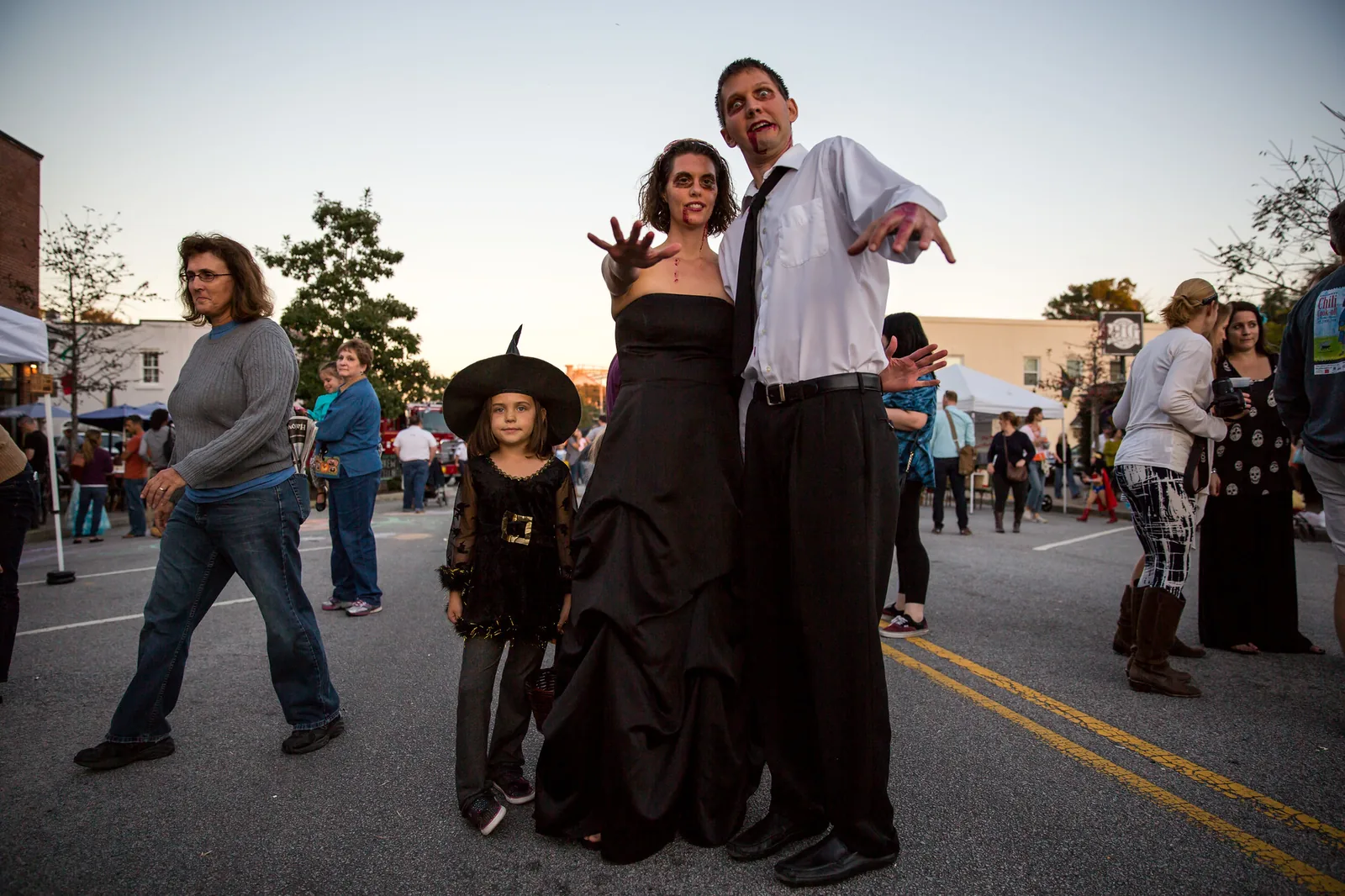 A family in zombie and witch costumes poses on East Montague Avenue during the North Charleston Harvest Festival.