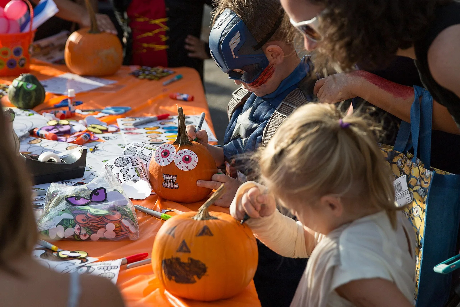 Children decorate pumpkins at a craft table during the North Charleston Harvest Festival in the Olde Village.