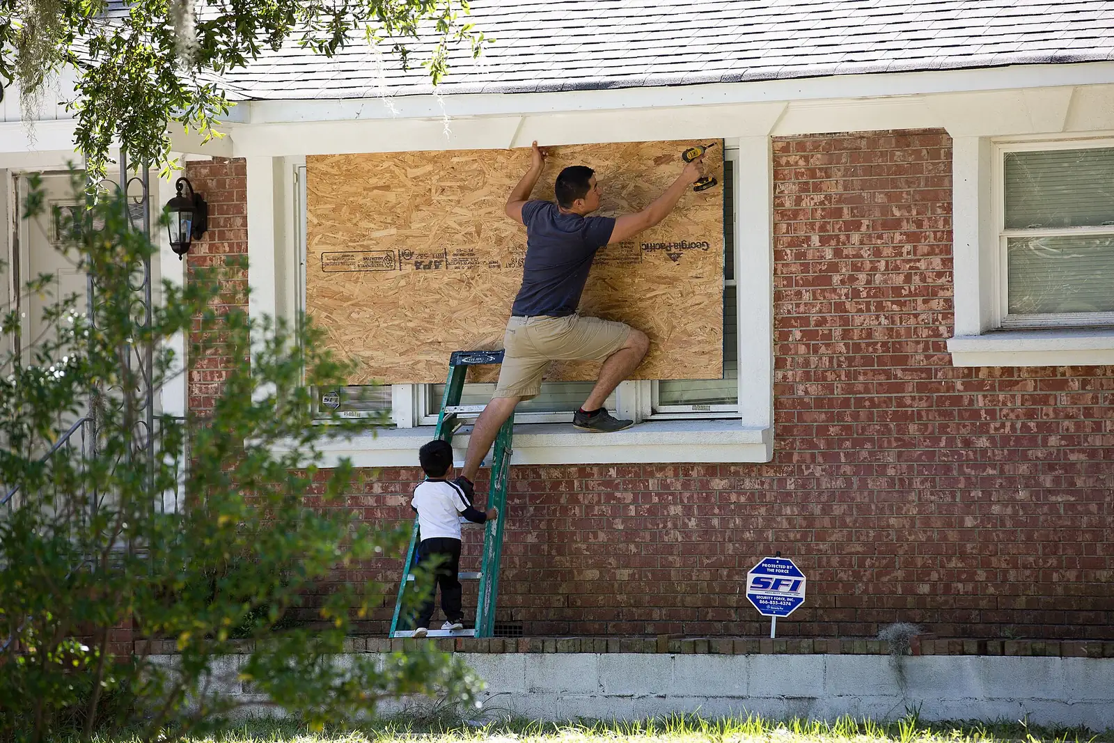 A North Charleston resident boards up a front window as Hurricane Matthew approaches.