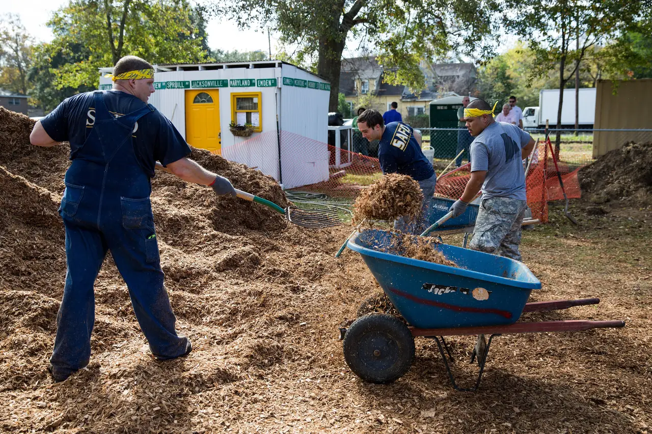 Volunteers spread mulch while building the playground at the Chicora-Cherokee Community Park, next to the Chicora Place Community Garden in North Charleston.