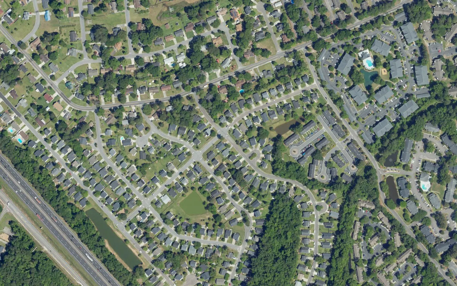 Aerial view of curving residential streets and apartment buildings in the Northwoods area of North Charleston, with Interstate 26 at lower left.