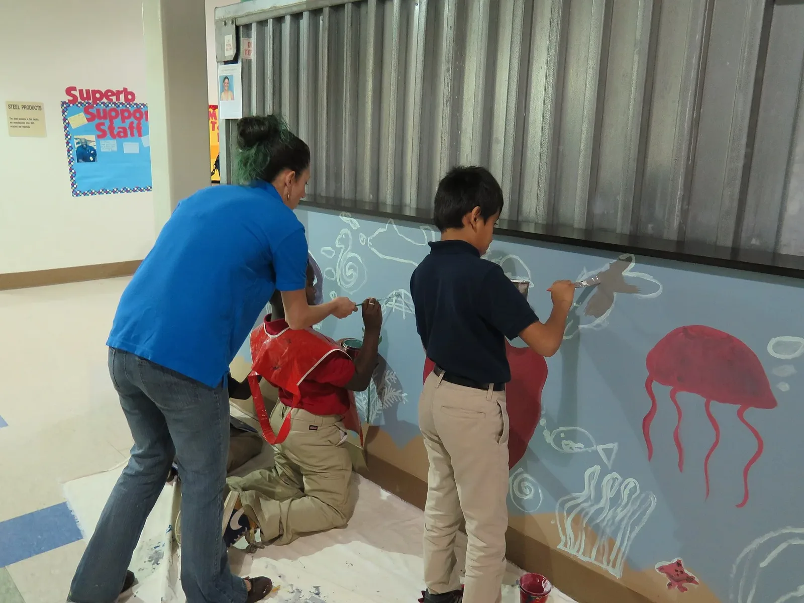 Students work on a mural with the city's artist-in-residence in a hallway at North Charleston Elementary School.
