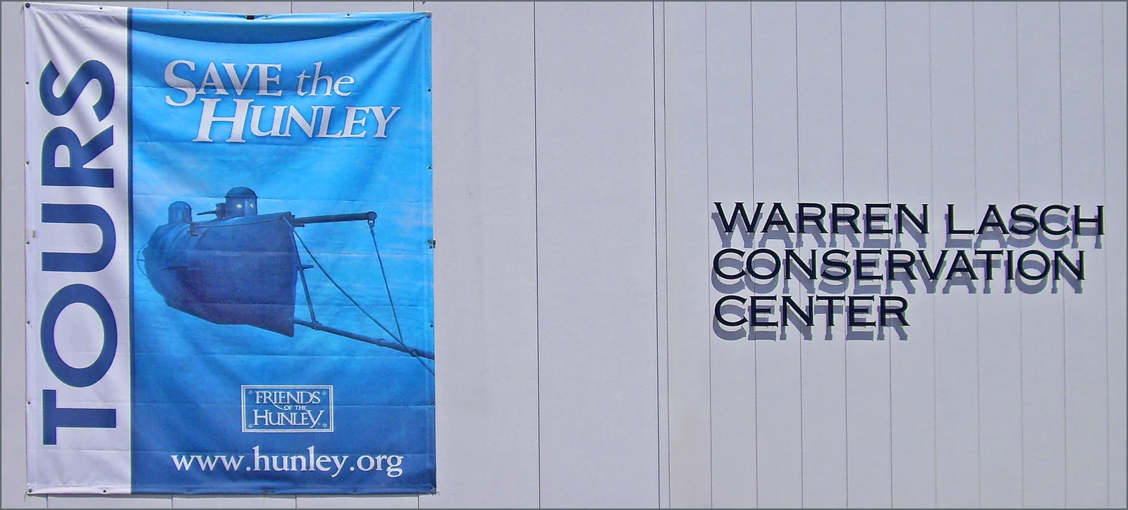 A Save the Hunley tours banner on the Warren Lasch Conservation Center, where the H.L. Hunley submarine is conserved in North Charleston.