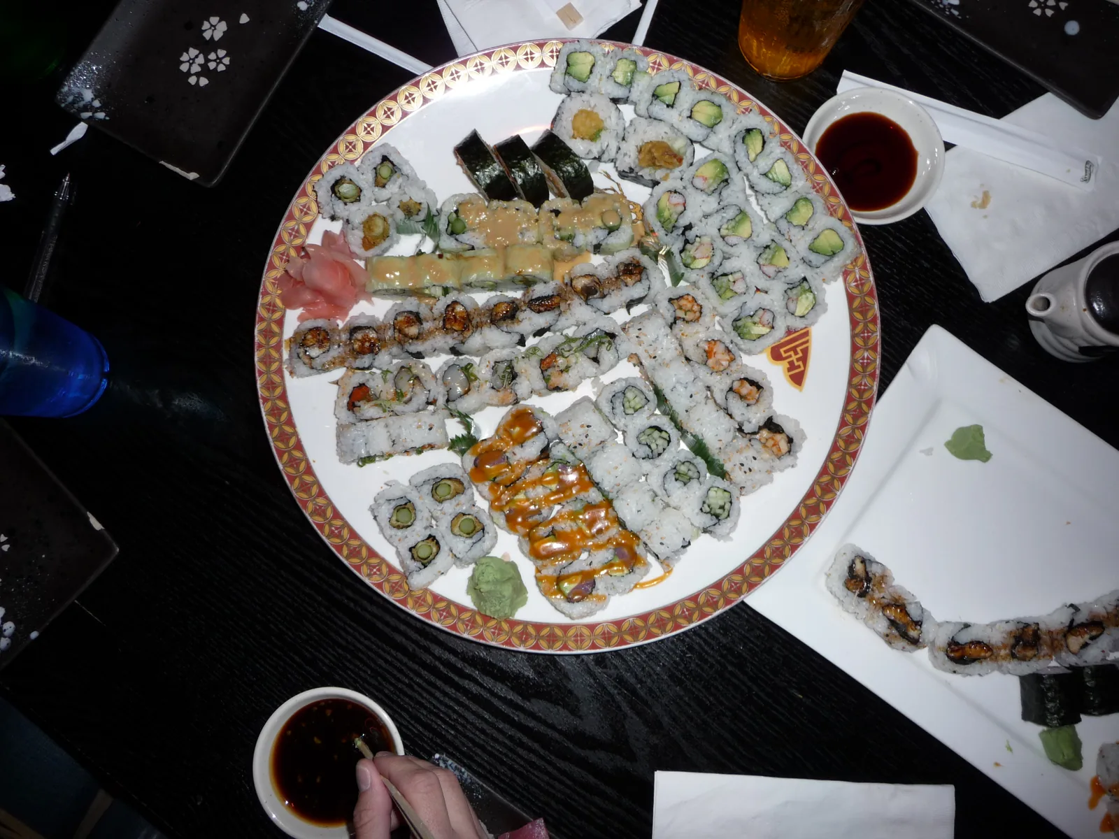 A platter of assorted sushi rolls with soy sauce. The photo was not taken in North Charleston.