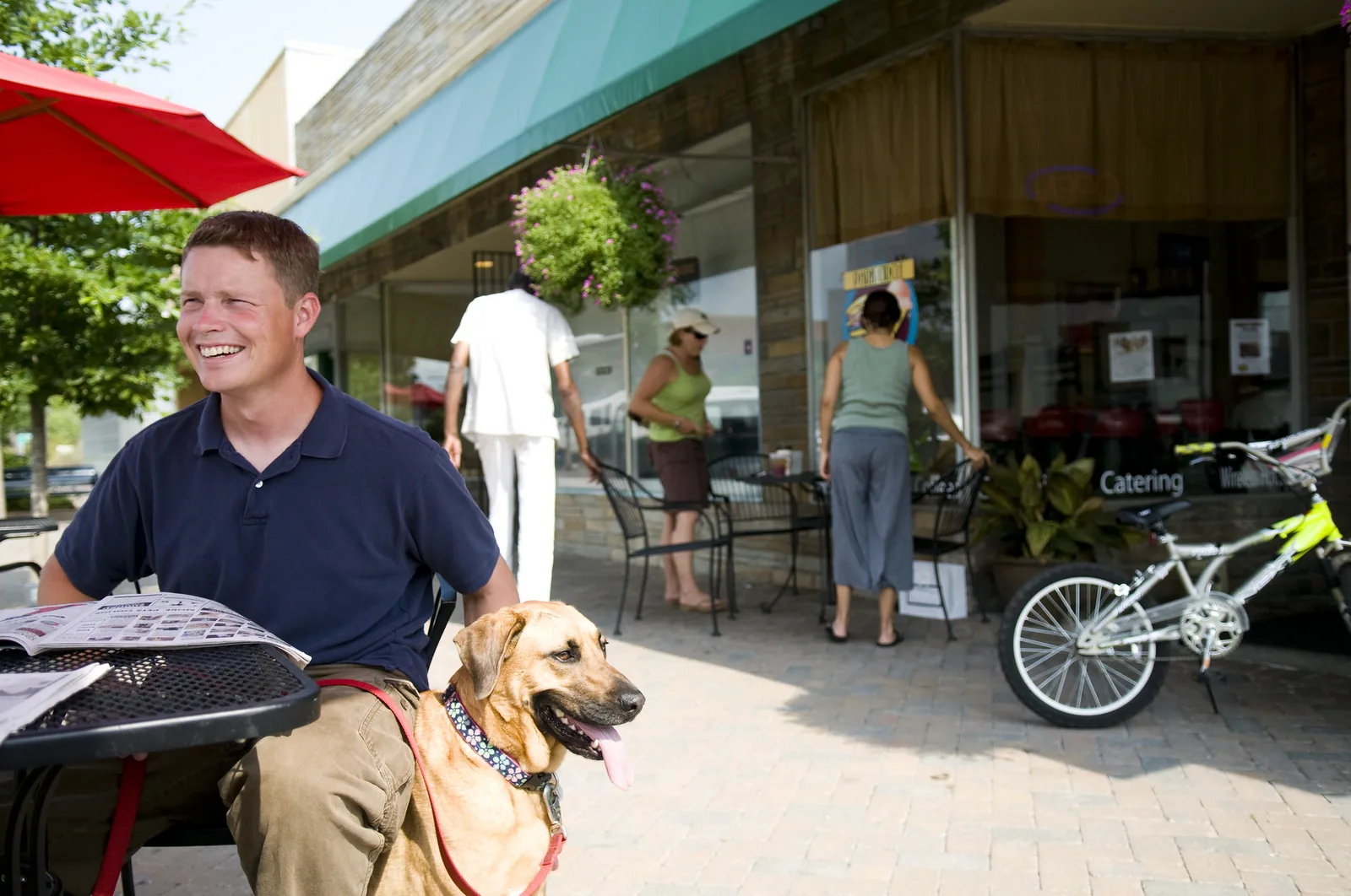 People at cafe tables on the sidewalk of East Montague Avenue in Park Circle's Olde Village.